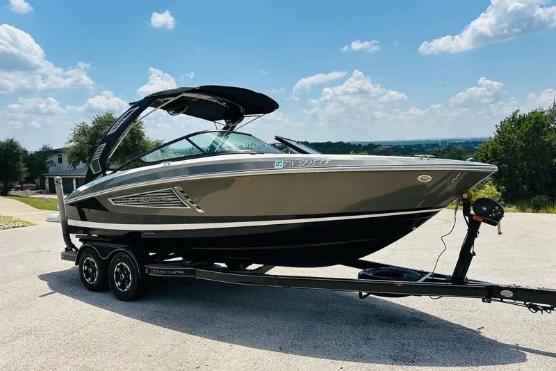 Slide: The Image of 2018 Regal 2300 Bowrider boat on trailer under a clear blue sky. - 10