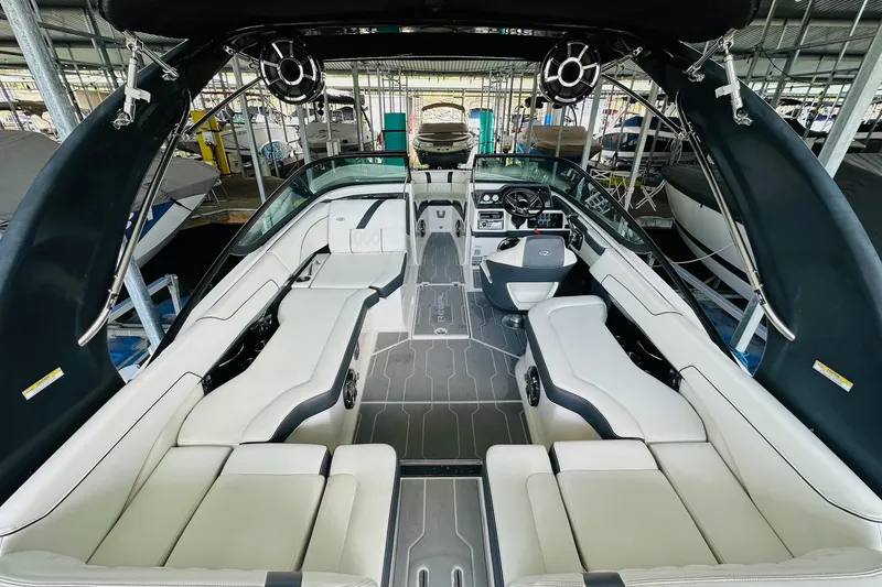 Slide: The Image of 2018 Regal 2300 Bowrider interior with sleek seating and modern dashboard in a marina setting. - 15
