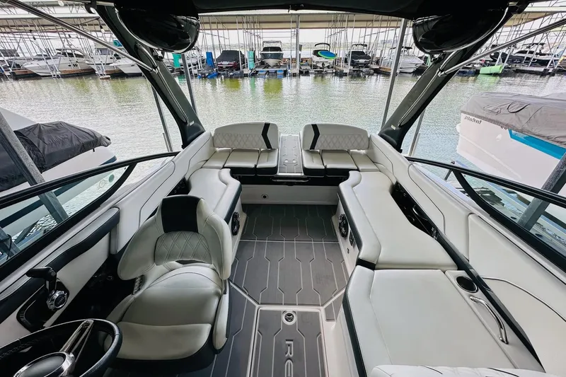 Slide: The Image of 2018 Regal 2300 Bowrider interior with luxurious seating and modern design in a marina setting. - 17