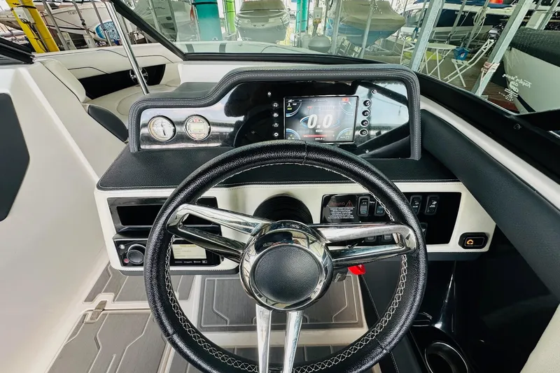 Slide: The Image of 2018 Regal 2300 Bowrider dashboard with steering wheel and digital display. - 19