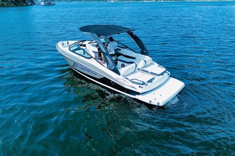 Slide: The Image of 2018 Regal 2300 Bowrider cruising on a serene lake under clear blue skies. - 3