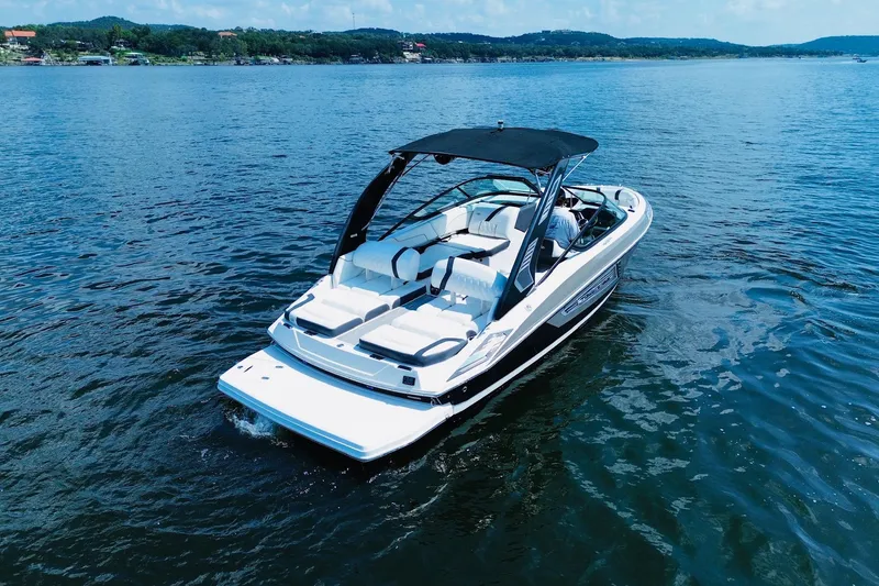 Slide: The Image of 2018 Regal 2300 Bowrider boat cruising on a serene lake under a clear sky. - 4
