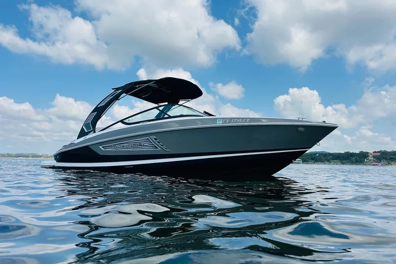Slide: The Image of 2018 Regal 2300 Bowrider on calm water under a blue sky with clouds. - 5