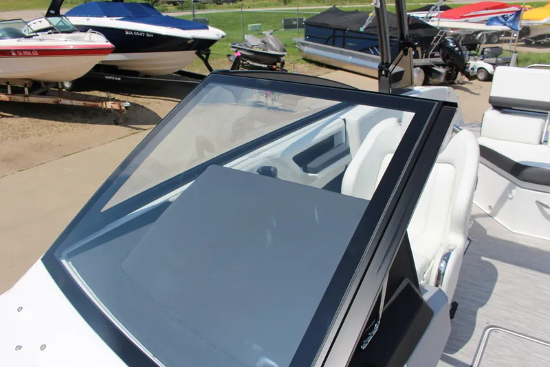 Slide: The Image of 2025 Cobalt R4 boat with sleek windshield and white interior, docked among other boats. - 12