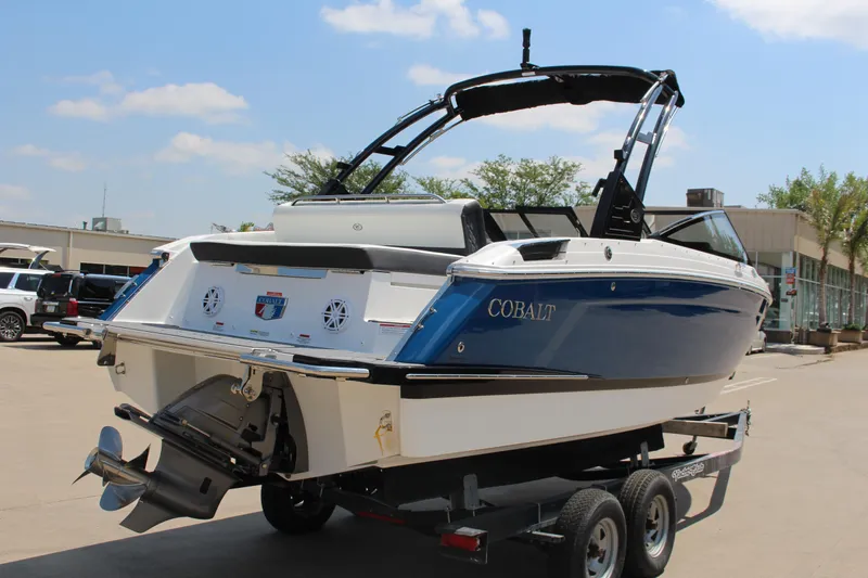 Slide: The Image of 2025 Cobalt R4 boat on trailer, blue and white design, outdoor dealership setting. - 3