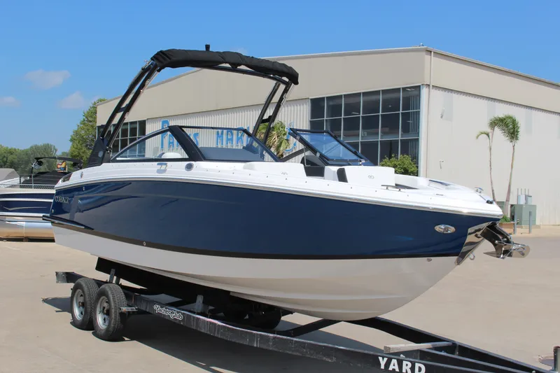 Slide: The Image of 2025 Cobalt R4 boat on trailer, parked outside a marine facility. - 30