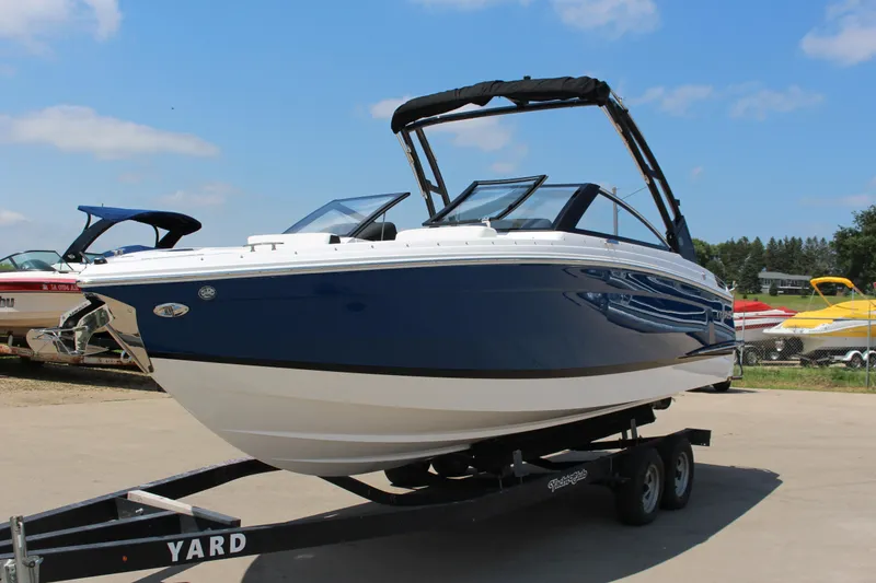 Slide: The Image of 2025 Cobalt R4 boat on trailer, blue and white design, parked outdoors. - 32