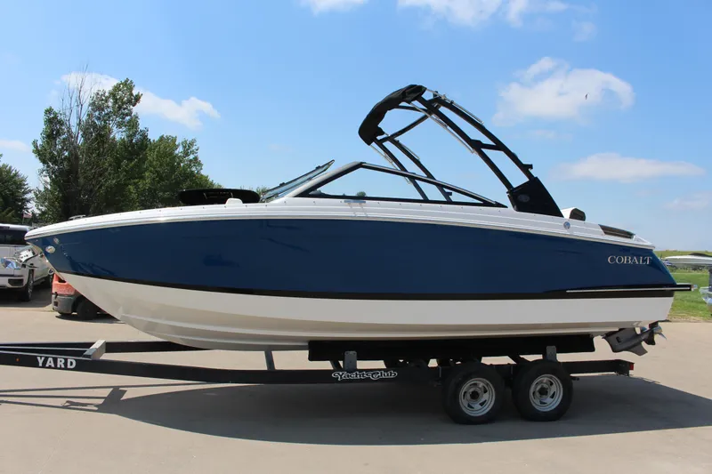 Slide: The Image of 2025 Cobalt R4 boat on trailer, blue and white design, parked outdoors. - 33