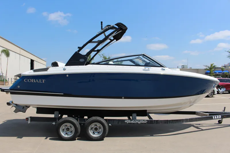 Slide: The Image of 2025 Cobalt R4 boat on trailer, blue and white design, parked outdoors. - 4