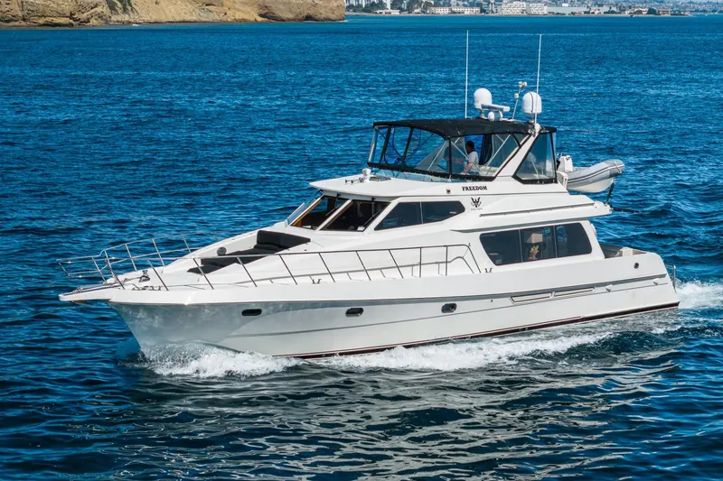 The Image of 2002 McKinna 57 Pilothouse yacht cruising on blue ocean waters. - 1