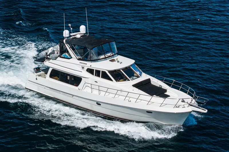 Slide: The Image of 2002 McKinna 57 Pilothouse yacht cruising on open water. - 12
