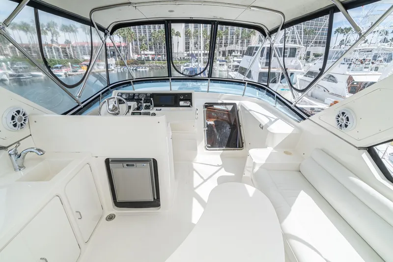 Slide: The Image of 2002 McKinna 57 Pilothouse interior with helm, seating, and marina view. - 14