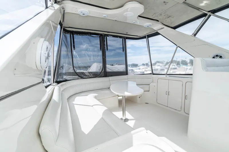 Slide: The Image of Luxurious interior of a 2002 McKinna 57 Pilothouse yacht with white seating and panoramic windows. - 20