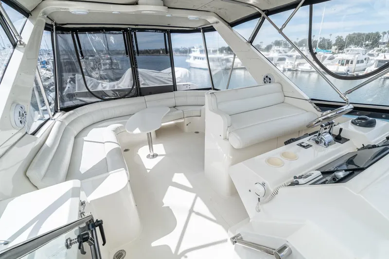 Slide: The Image of Luxurious 2002 McKinna 57 Pilothouse interior with white seating and helm, docked at marina. - 21