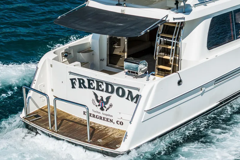 Slide: The Image of 2002 McKinna 57 Pilothouse yacht "Freedom" cruising on blue ocean waters. - 25