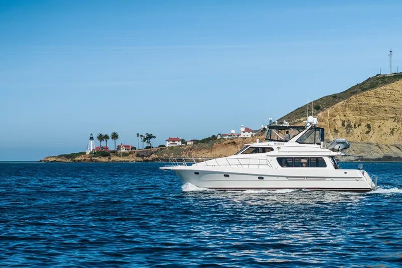 Slide: The Image of 2002 McKinna 57 Pilothouse yacht cruising near scenic coastal landscape. - 4