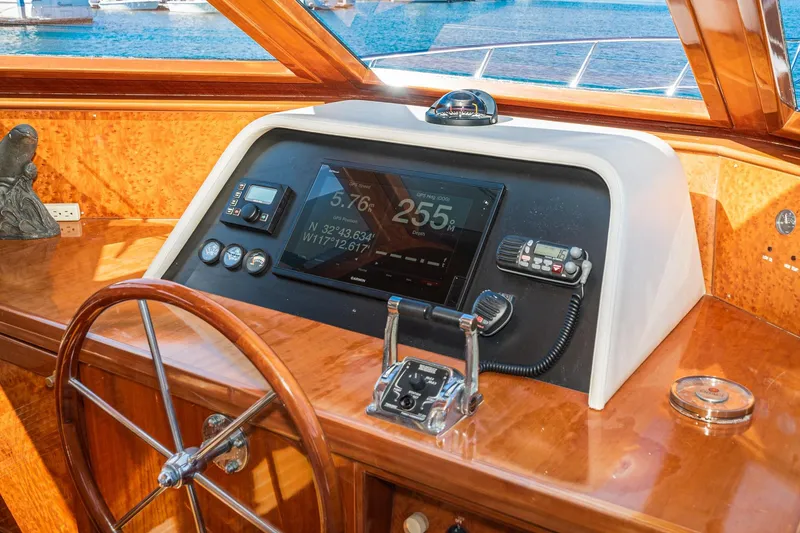 Slide: The Image of 2002 McKinna 57 Pilothouse helm with navigation controls and wooden steering wheel. - 45