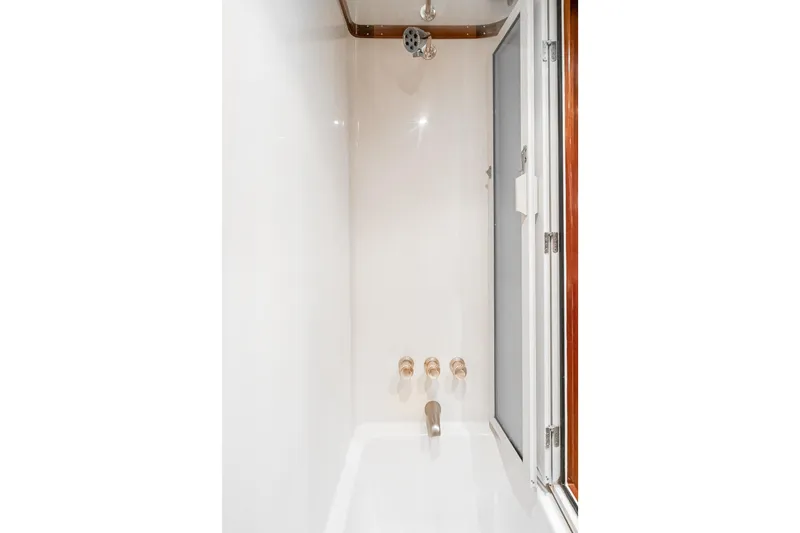 Slide: The Image of Shower area in 2002 McKinna 57 Pilothouse yacht, featuring sleek fixtures and white interior. - 54