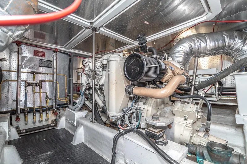 Slide: The Image of Engine room of 2002 McKinna 57 Pilothouse yacht, showcasing mechanical components and piping. - 67