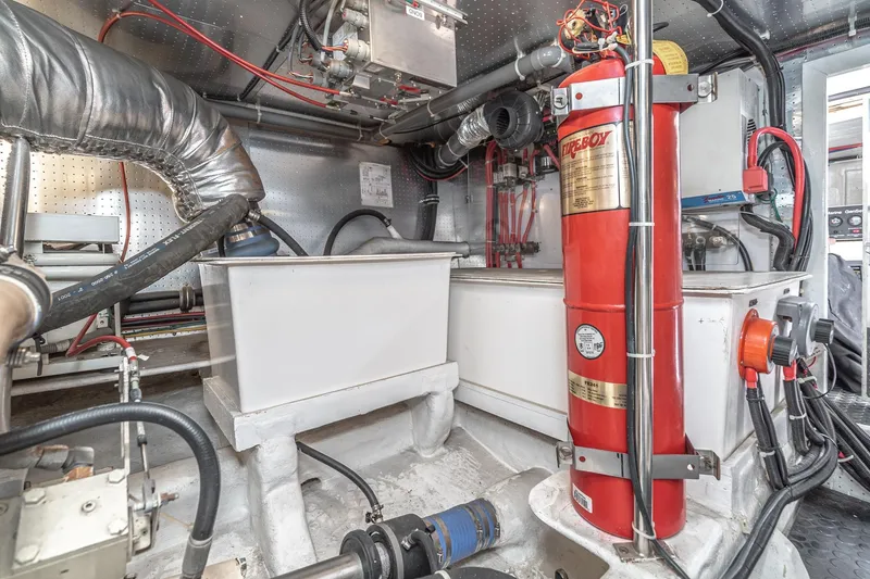 Slide: The Image of Engine room of 2002 McKinna 57 Pilothouse with fire extinguisher and mechanical components. - 70