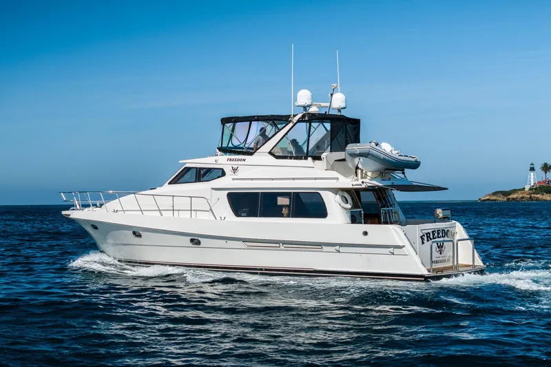 Slide: The Image of 2002 McKinna 57 Pilothouse yacht cruising on open water near a lighthouse. - 8