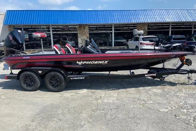 The Image of 2026 Phoenix 721xl bass boat with trailer, parked outside dealership. - 1