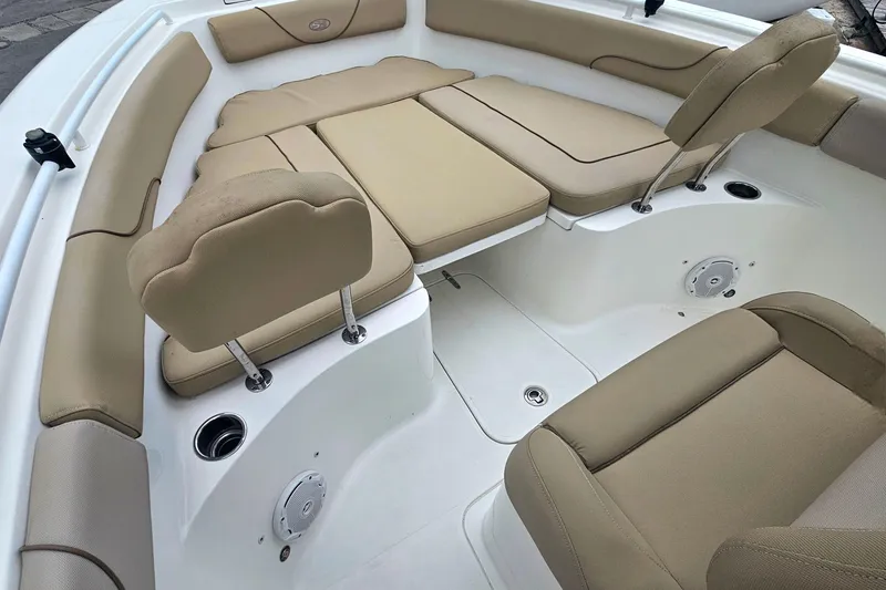 Slide: The Image of 2016 Sea Hunt Gamefish 25 boat interior with beige cushioned seating and cup holders. - 18