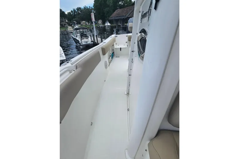 Slide: The Image of 2016 Sea Hunt Gamefish 25 boat interior with clean white deck and seating. - 21