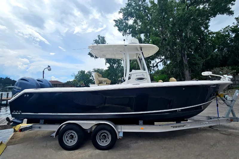 Slide: The Image of 2016 Sea Hunt Gamefish 25 boat on trailer, parked outdoors under cloudy sky. - 3