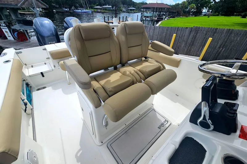 Slide: The Image of 2016 Sea Hunt Gamefish 25 boat interior with dual captain's chairs and steering console. - 4