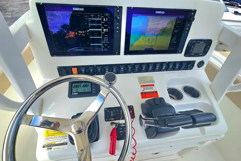 Slide: The Image of 2016 Sea Hunt Gamefish 25 dashboard with dual Simrad displays and steering wheel. - 6