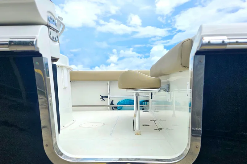 Slide: The Image of 2016 Sea Hunt Gamefish 25 boat interior with seating, under a bright blue sky. - 8