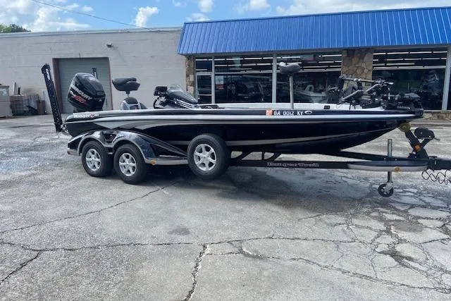Slide: The Image of 2014 Ranger 520C boat on trailer, parked outside a building with blue awning. - 7