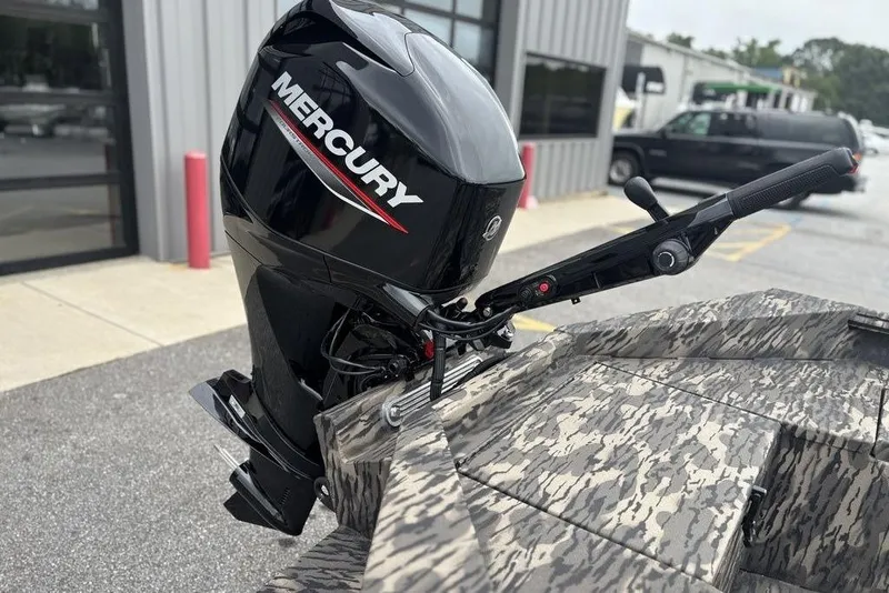 Slide: The Image of 2025 Havoc 1756 MRST boat with Mercury outboard motor, camo design, parked outside. - 14