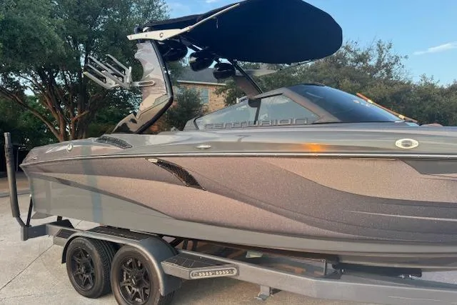 Slide: The Image of 2018 Centurion Fi23 boat on trailer, sleek design, gray color, outdoor setting. - 12