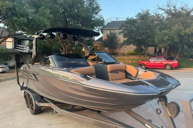 Slide: The Image of 2018 Centurion Fi23 boat on trailer, parked in residential area. - 2