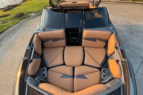 Slide: The Image of 2018 Centurion Fi23 boat with tan leather seating and cup holders, docked on concrete. - 3