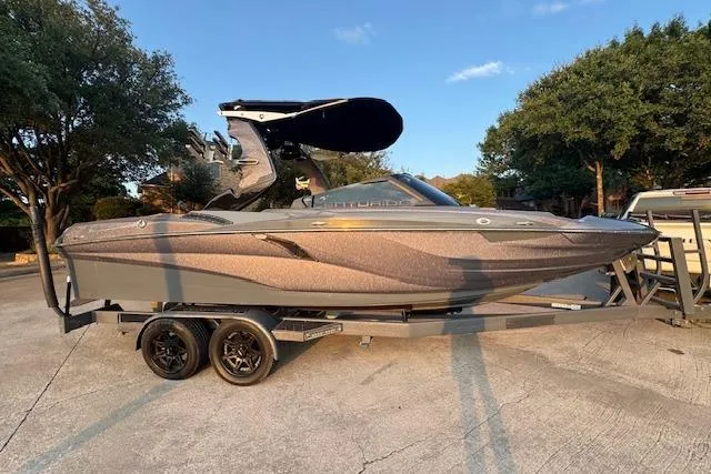 Slide: The Image of 2018 Centurion Fi23 boat on trailer, parked outdoors under clear sky. - 4