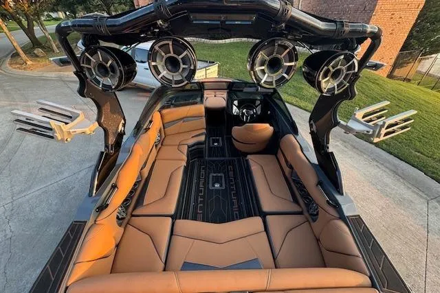 Slide: The Image of 2018 Centurion Fi23 boat interior with tan seating, advanced sound system, and sleek design. - 6