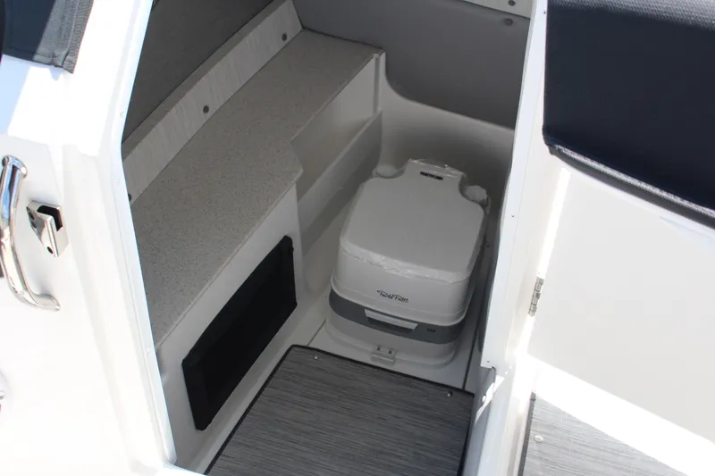 Slide: The Image of Interior of 2025 Cobalt R8 boat featuring a compact portable toilet. - 17