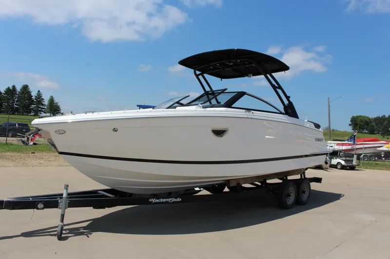 Slide: The Image of 2025 Cobalt R8 boat on trailer, sleek design, parked outdoors under blue sky. - 2