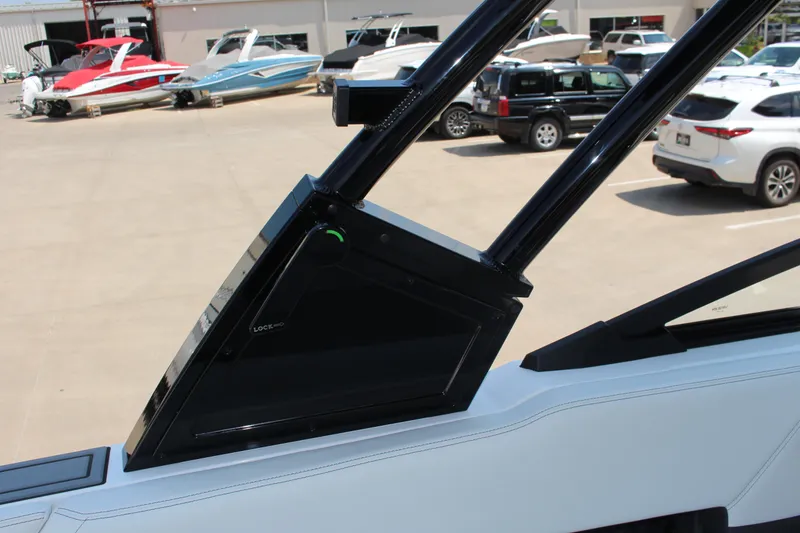 Slide: The Image of 2025 Cobalt R8 boat detail with sleek black frame and lock mechanism in a marina setting. - 28
