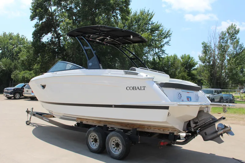 Slide: The Image of 2025 Cobalt R8 boat on trailer, parked outdoors with trees in background. - 4