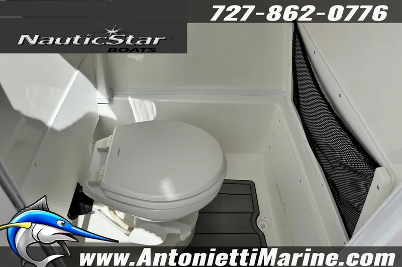 Slide: The Image of 2026 NauticStar 251 Hybrid boat interior with toilet, featuring storage netting. - 19
