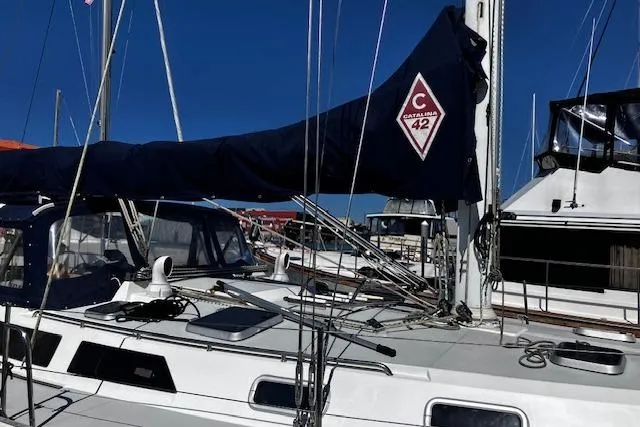Slide: The Image of 1992 Catalina 42' MkII sailboat docked, featuring a covered mainsail and sleek design. - 1