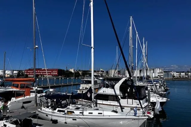 Slide: The Image of Sailboats docked at a marina, featuring a 1992 Catalina 42' MkII under a clear blue sky. - 2