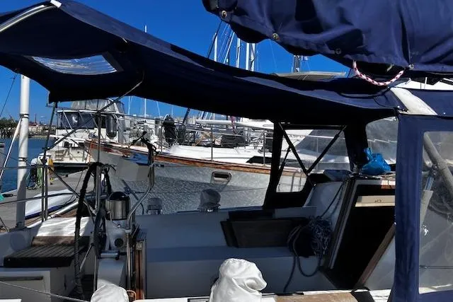 Slide: The Image of 1992 Catalina 42' MkII sailboat docked, featuring a covered cockpit and marina backdrop. - 4