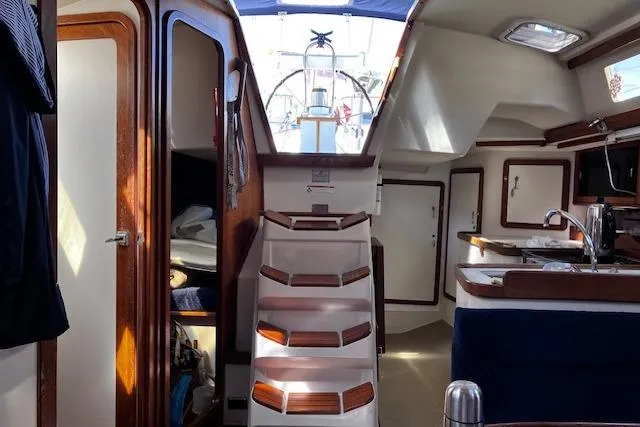 Slide: The Image of Interior of a 1992 Catalina 42' MkII sailboat, featuring wooden cabinetry and a compact kitchen. - 6