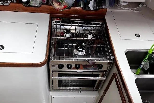 Slide: The Image of Compact kitchen area in a 1992 Catalina 42' MkII sailboat with stove and sink. - 9