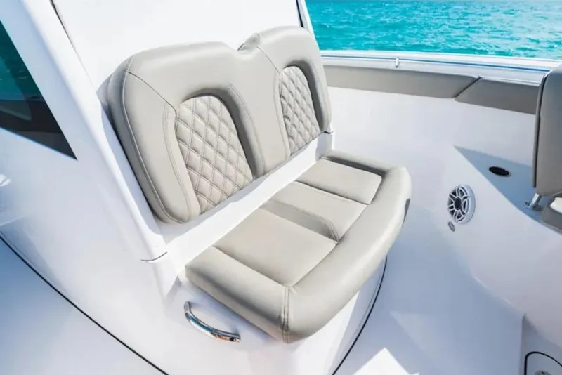 Slide: The Image of 2026 Sportsman Open 302 Center Console boat seat with quilted design, ocean backdrop. - 11